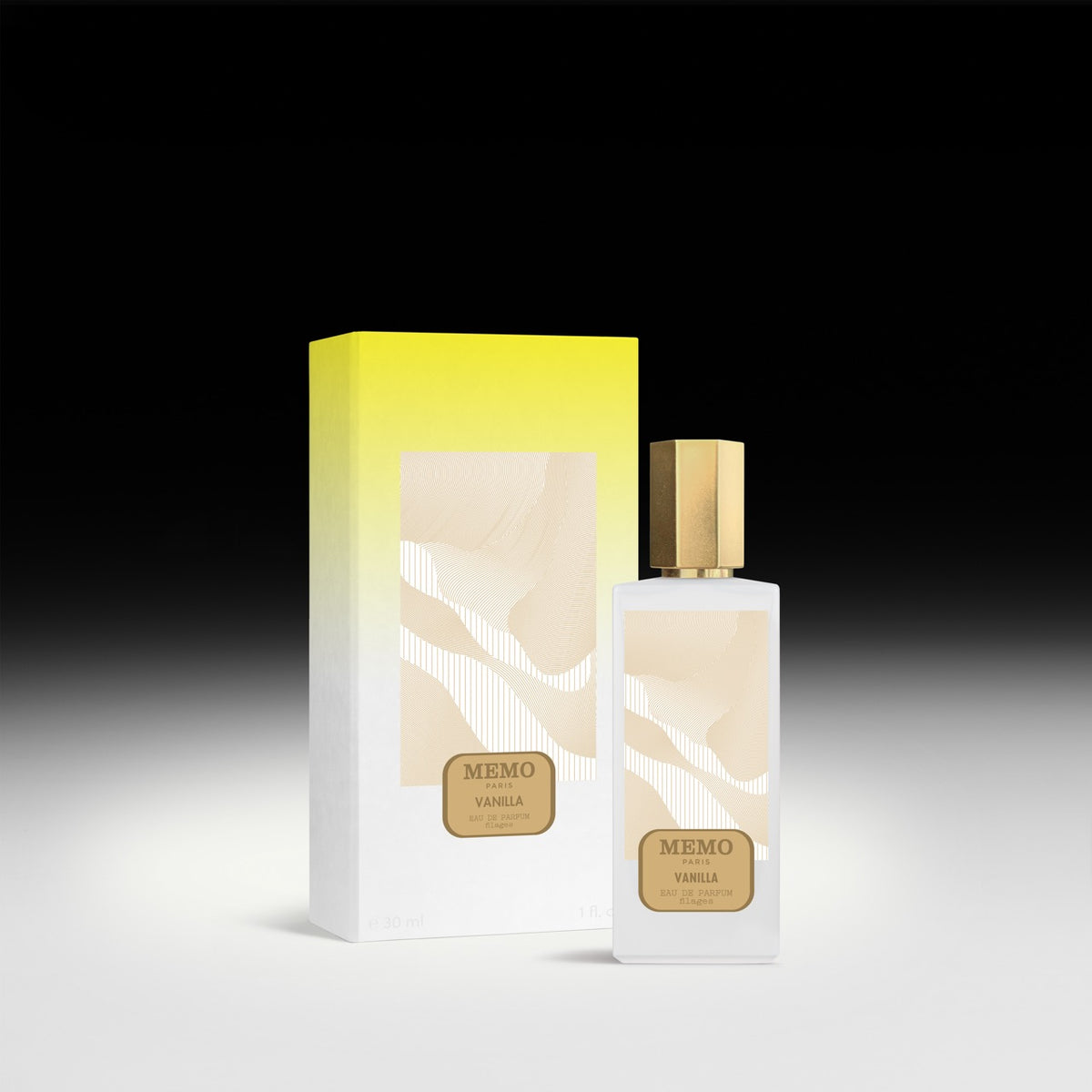 A sleek white glass bottle of memo paris essences filages vanilla eau de parfum with gold cap beside its box