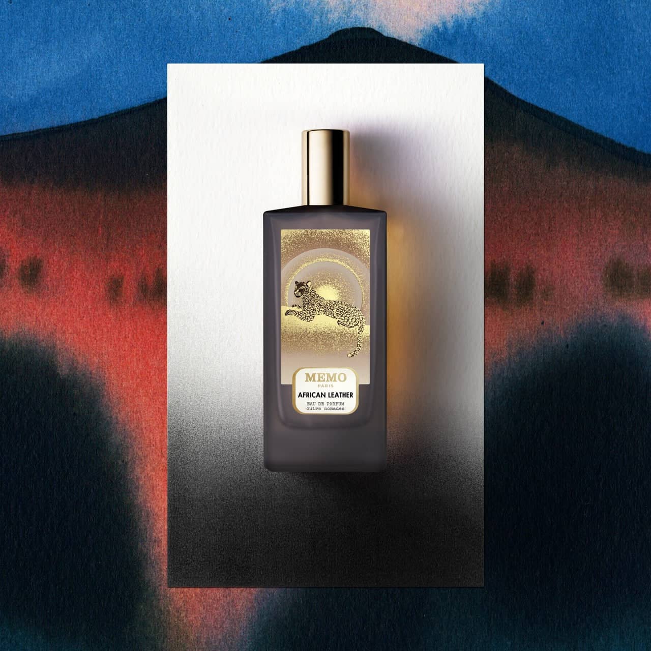 Dark gray rectangular perfume bottle with a gold cap and label featuring an embossed golden leopard design, labeled ’memo paris african leather eau de parfum’.
