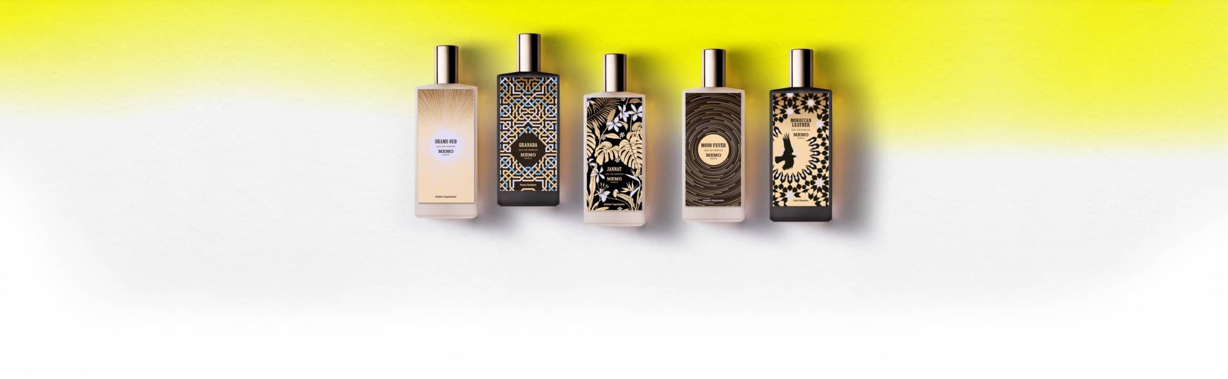 Five rectangular perfume bottles with metallic caps and varied decorative labels in black, gold, or beige tones.